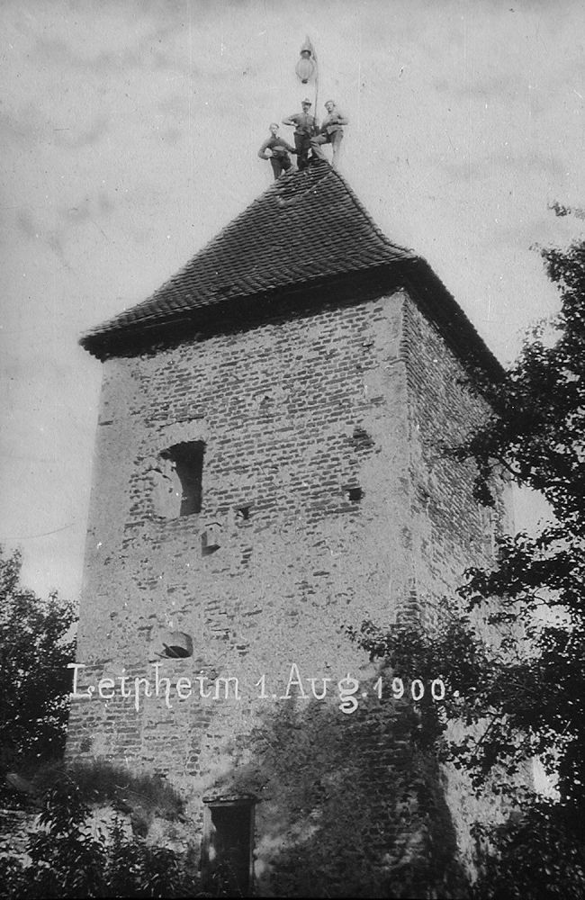 Arbeiter befestigen am 1. August 1900 einen Dachständer auf dem Wasserturm - in Leipheim wird zu diesem Zeitpunkt eine neue Ära eingeläutet: Die der elektrischen Beleuchtung.
